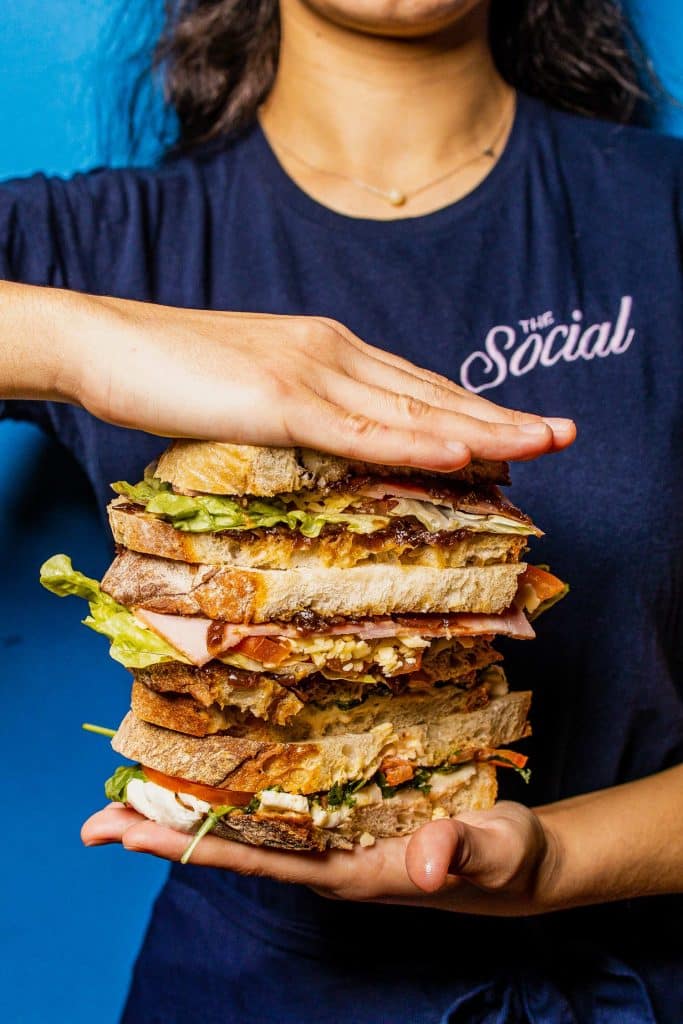 Woman holding a tall sandwich